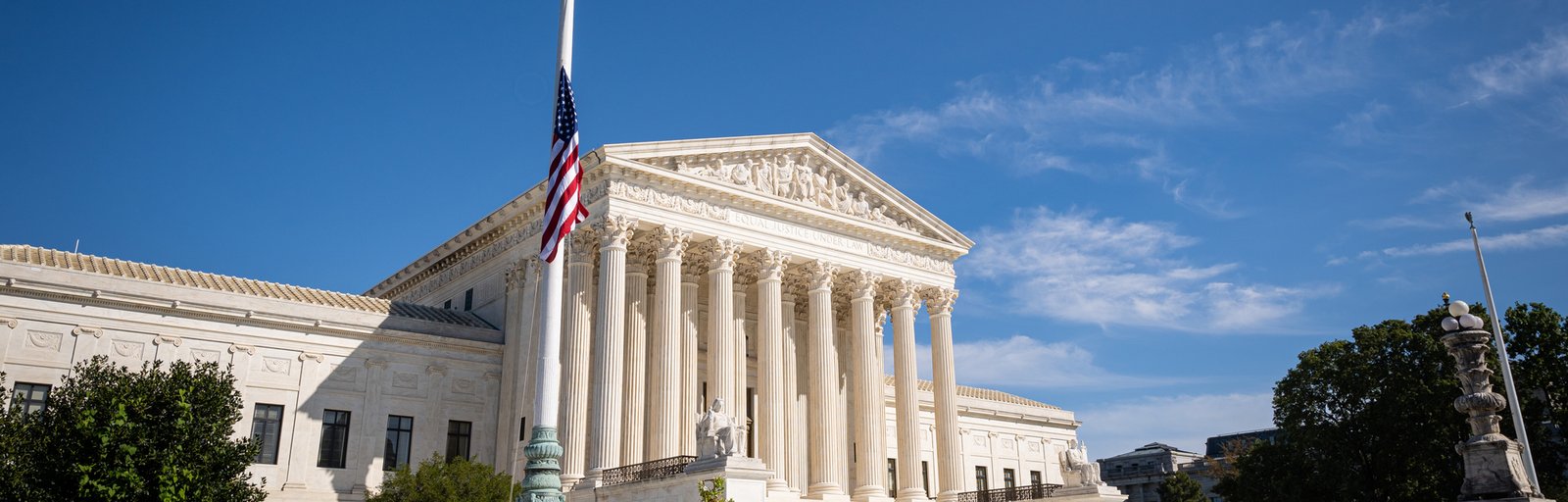 Courthouse building with classical architecture, featuring tall columns and a statue, American flag at half-mast, symbolizing justice and legal representation in Central Florida.